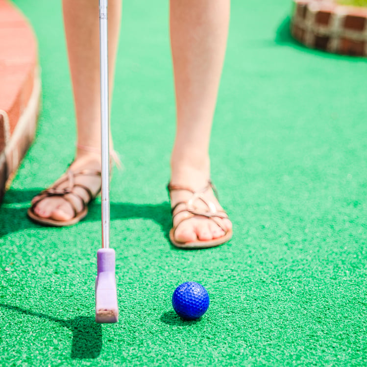 Teen girl play mini-golf